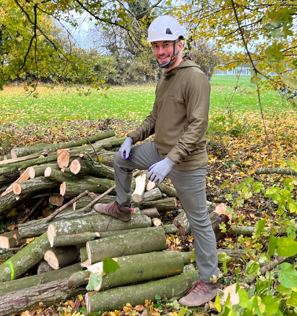 Tim from Allies proudly stands by the woodpile